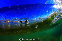 Veiw from under neath breaking wave, Father takes son int... by Dale Kobetich 